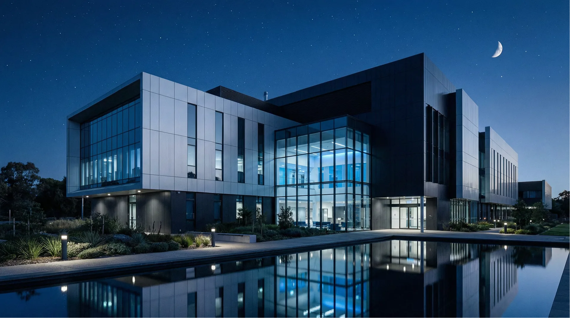 A modern hospital building illuminated at dusk